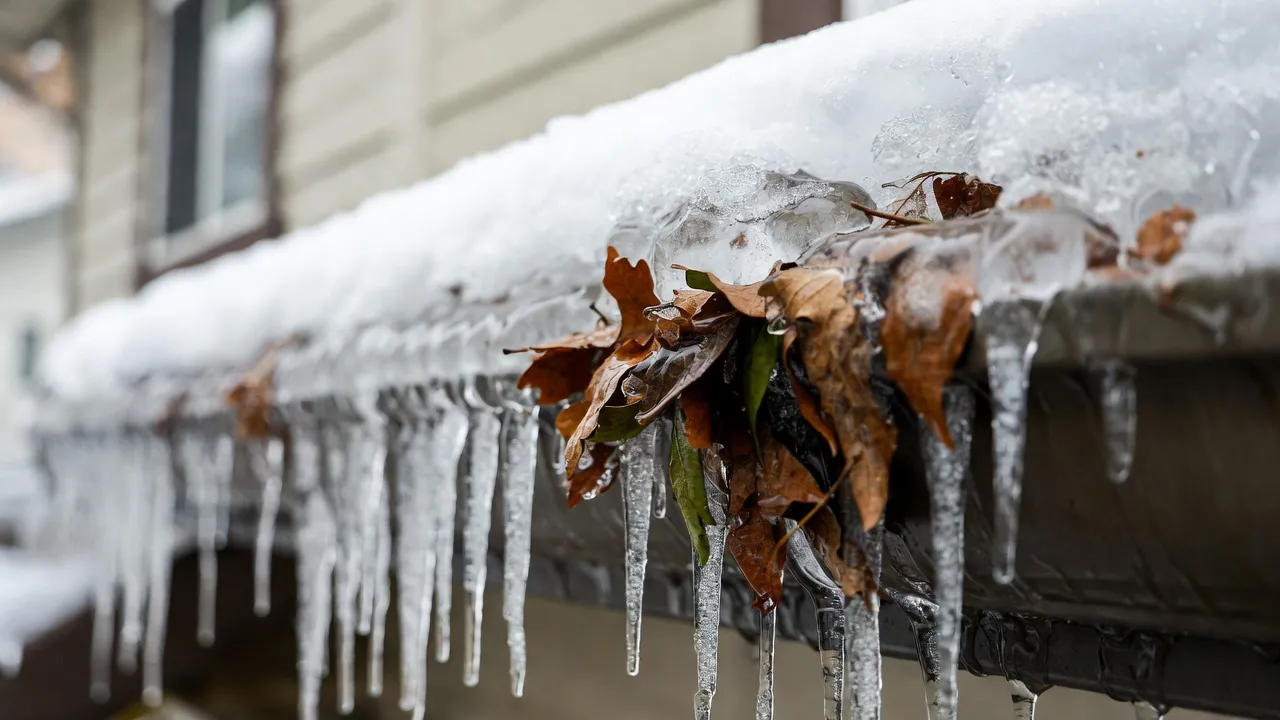 Ice dam removal on a Spokane home — low-pressure steam clearing ice buildup along the roof edge